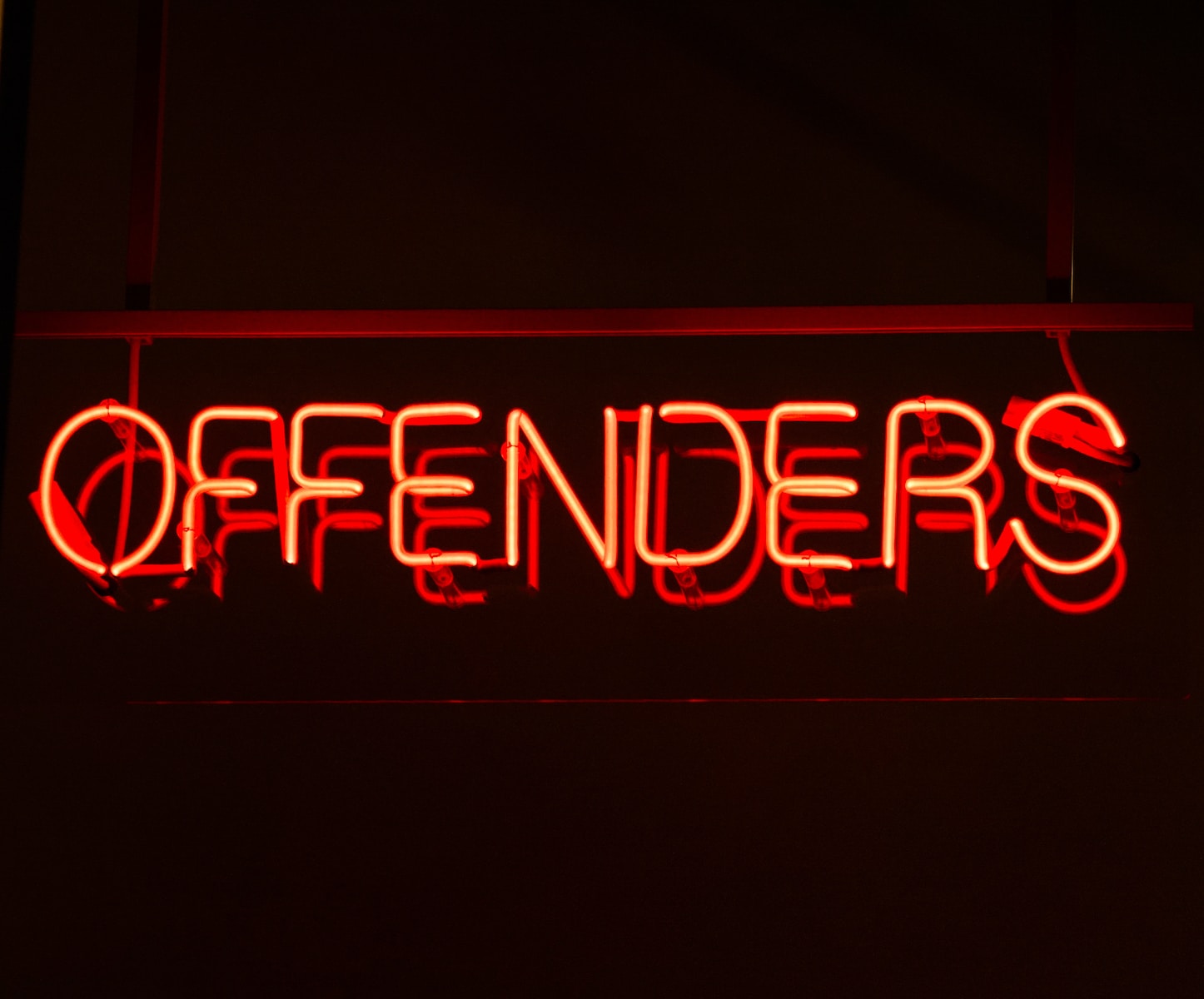 red neon lighted offenders signage