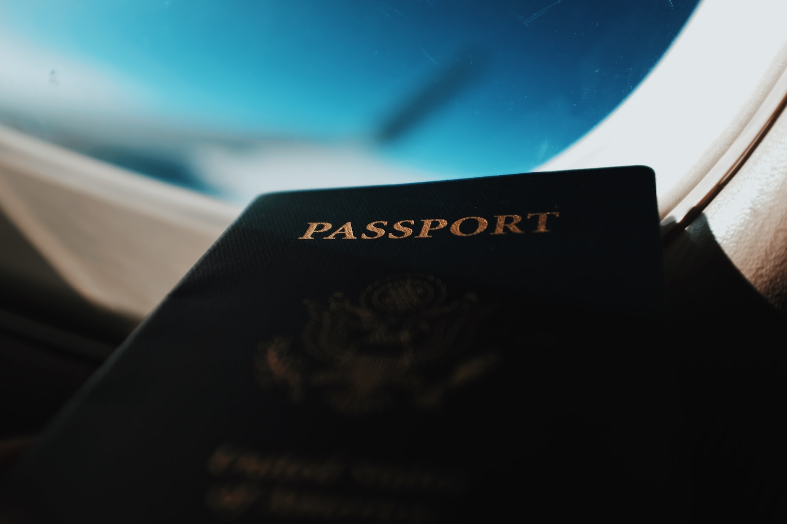 silhouette of passport booklet with airplane window background