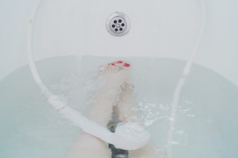 person sitting in white bathtub