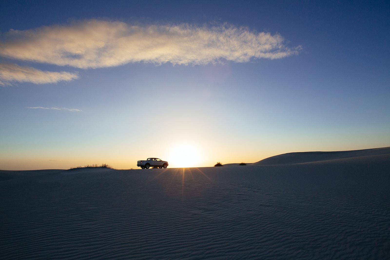 car on desert during sunset